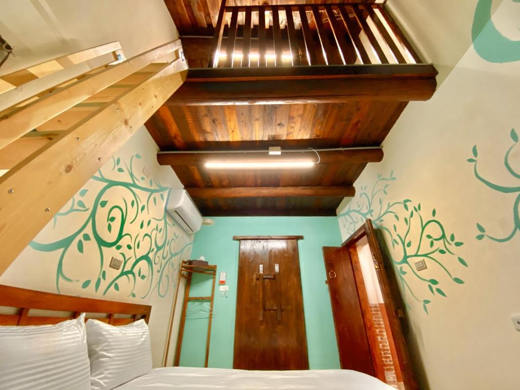 金湖镇金門玉宿古厝小包棟民宿的一间卧室设有一张床和木制楼梯。
