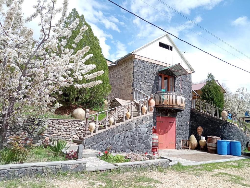 AreniLuiza Guest House的一座有红色门和石墙的房子