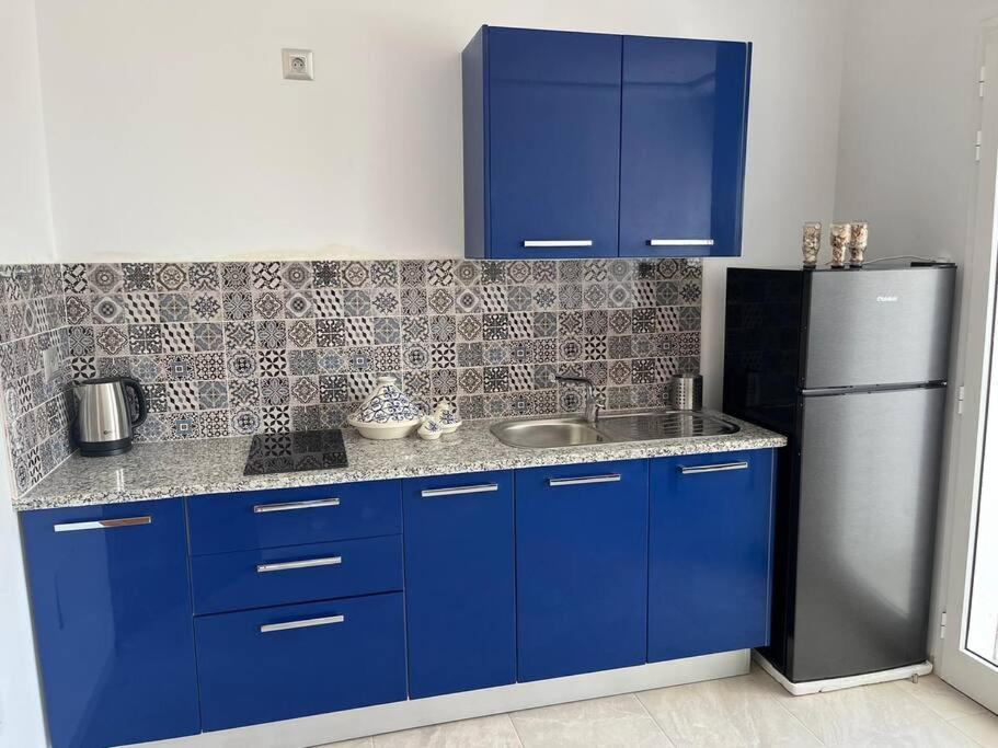迈来亚Studio Bleu Cosy à Dar Lili Djerba的厨房配有蓝色橱柜和不锈钢冰箱