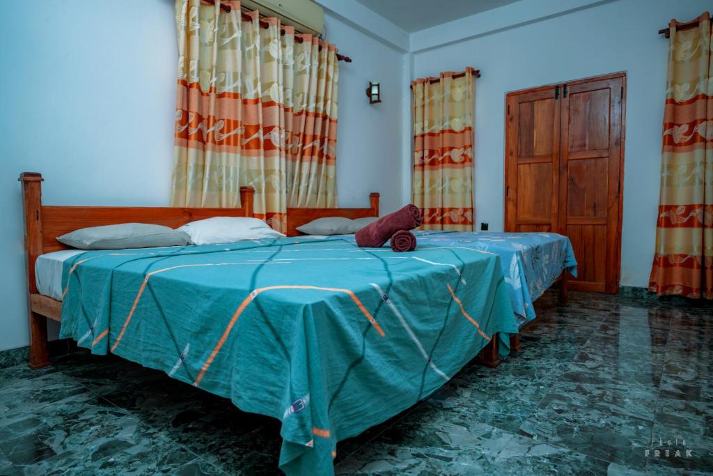 奇洛Hotel Athina & Restaurant的一间卧室配有一张带蓝色棉被的床