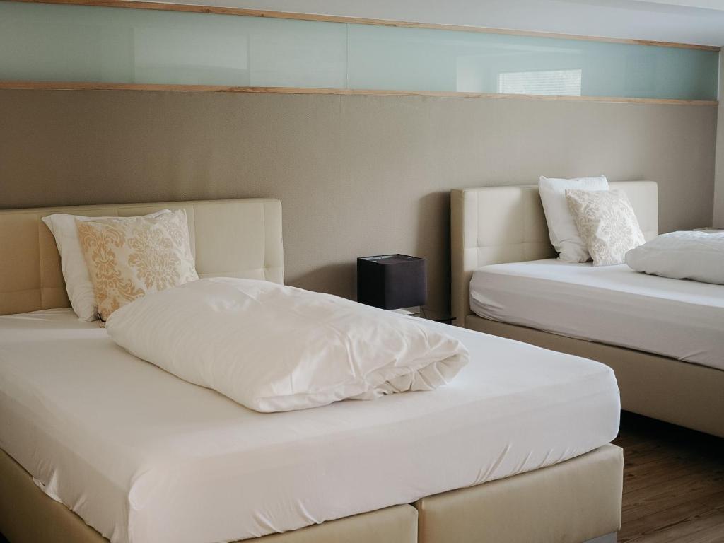 埃希特纳赫Appartement Meyer-Ernzen的配有2张床的带白色床单和枕头的客房