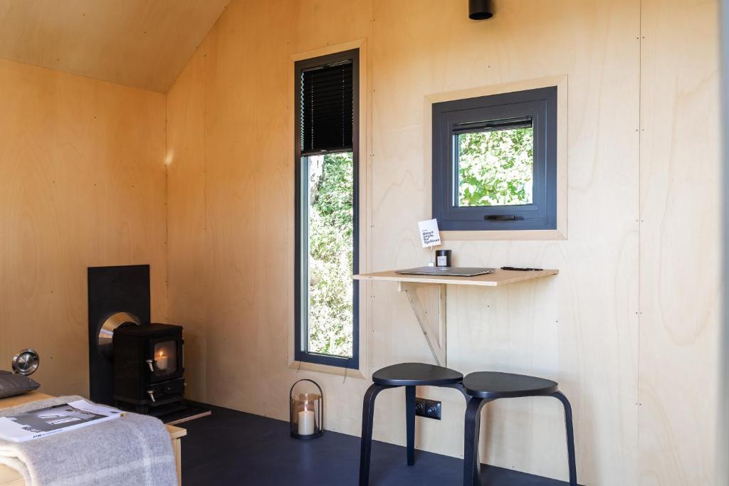 ÅrnesTiny House in the countryside的一个小房子里有两个凳子的房间