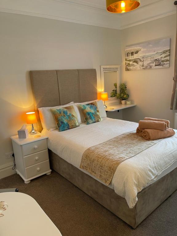 斯沃尼奇Rivendell Guest House的一间卧室配有一张大床和两盏灯