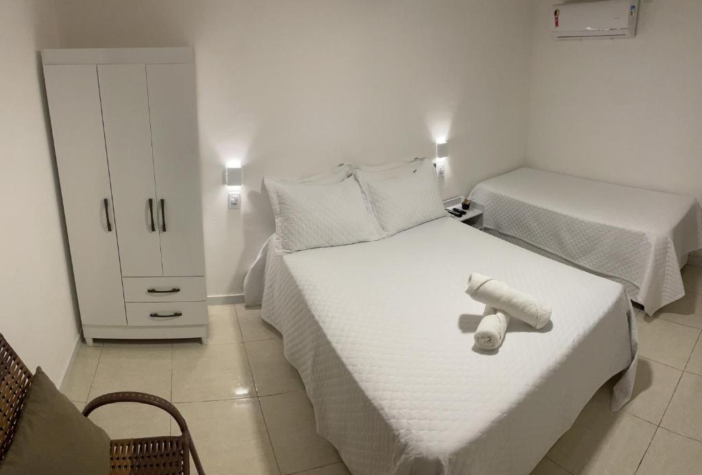 皮拉尼亚斯Caroá Piranhas Suítes的白色卧室配有两张床和白色橱柜