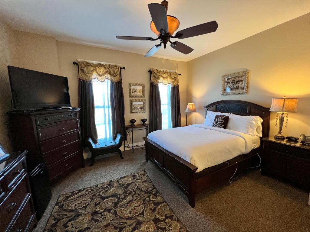 布兰森Historic Branson Hotel - Heritage Room with Queen Bed - Downtown - FREE TICKETS INCLUDED的一间卧室配有一张床和吊扇