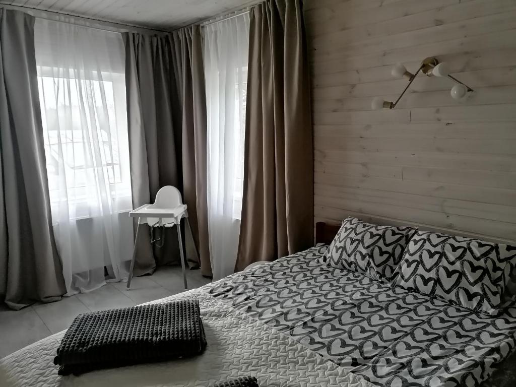 KščavaFOREST LAKE的一间卧室配有一张床和一个带椅子的窗户