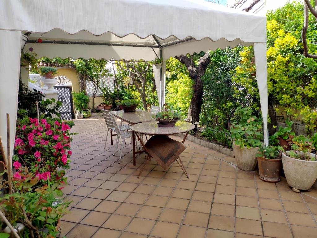 LanzahitaChalet en Valle del Tietar的一个带桌子和白色遮阳伞的庭院