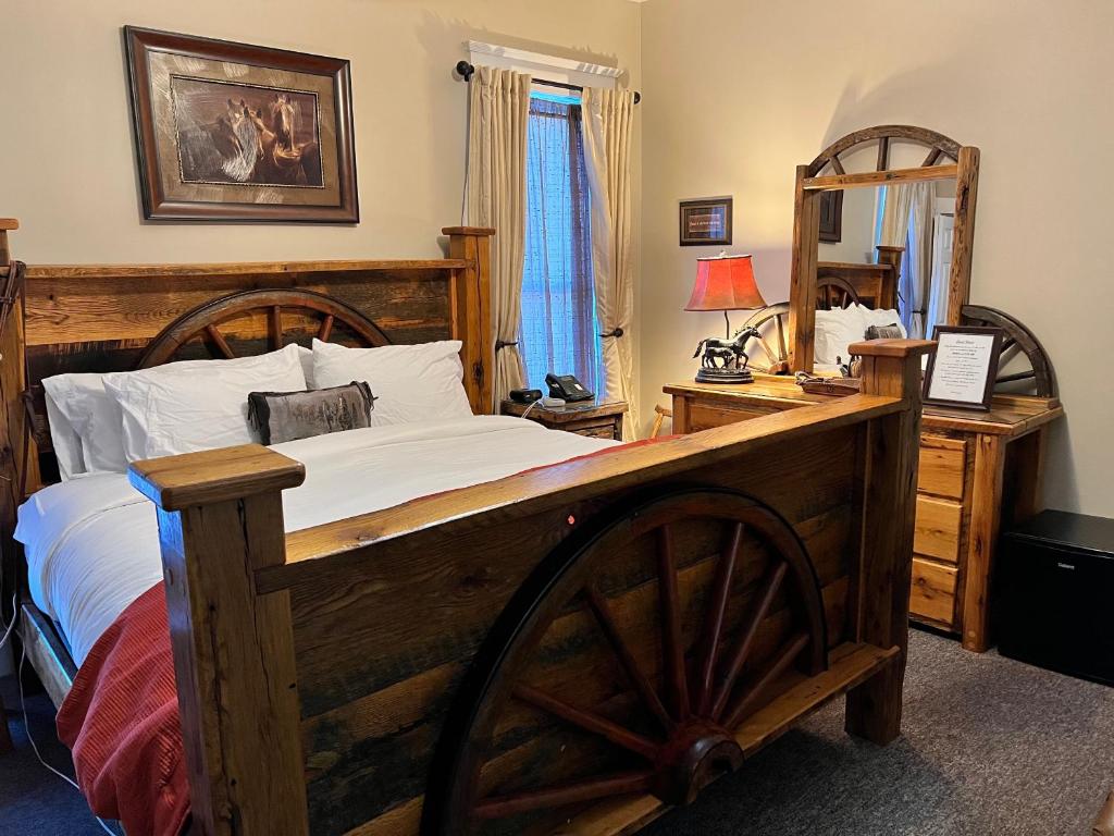 布兰森Historic Branson Hotel - Horseshoe Room with King Bed - Downtown - FREE TICKETS INCLUDED的一间卧室配有一张大木床和镜子