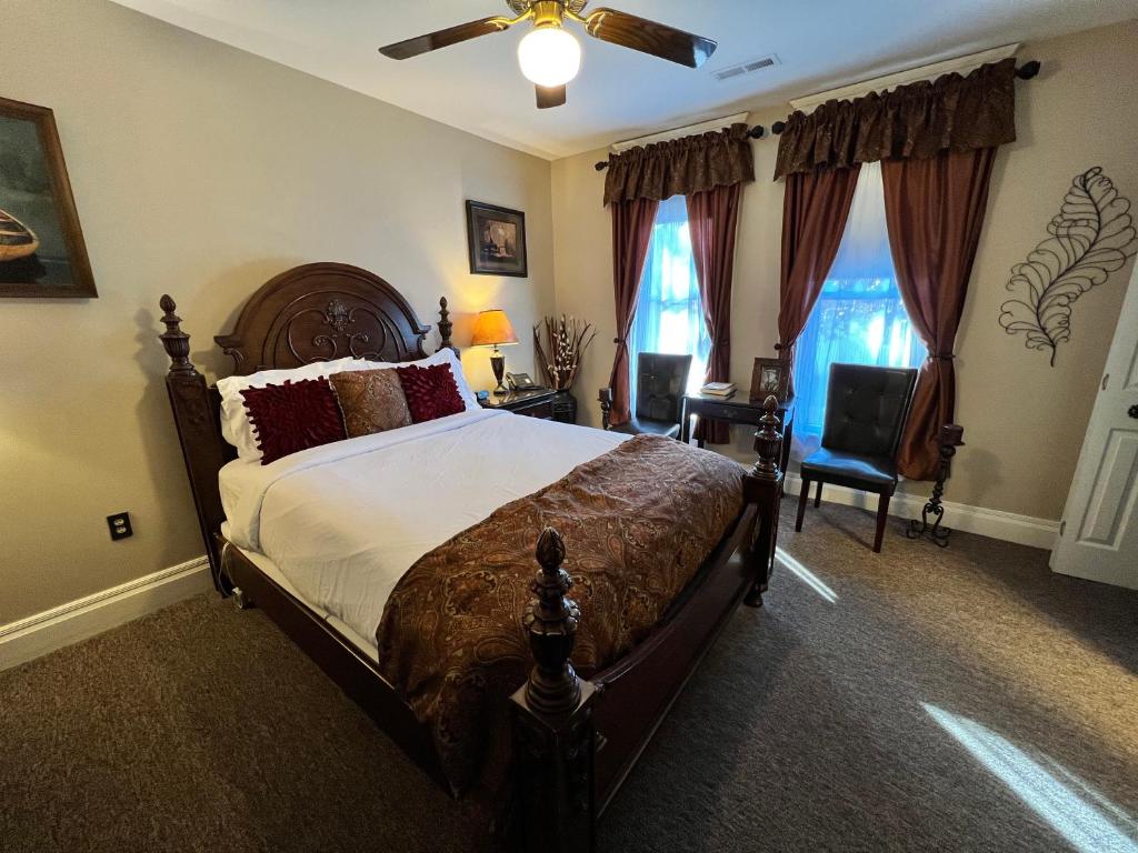 布兰森Historic Branson Hotel - Notebook Room with Queen Bed - Downtown - FREE TICKETS INCLUDED的一间卧室配有一张床和吊扇