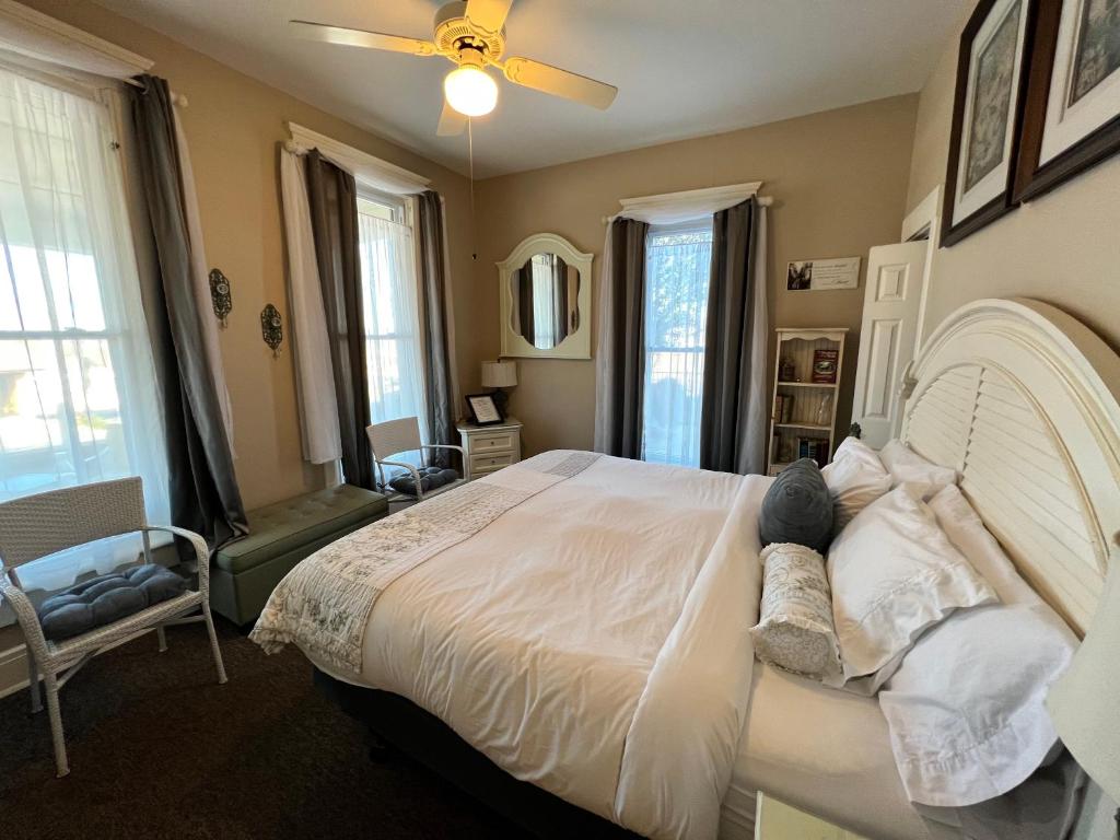 布兰森Historic Branson Hotel - Quiet Quilt Room with King Bed - Downtown - FREE TICKETS INCLUDED的卧室配有一张白色大床和吊扇