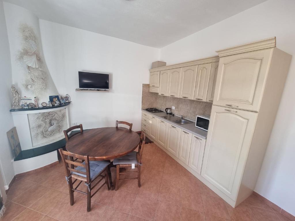阿尔扎凯纳Appartamento Monte Mare Arzachena的厨房配有木桌和冰箱。