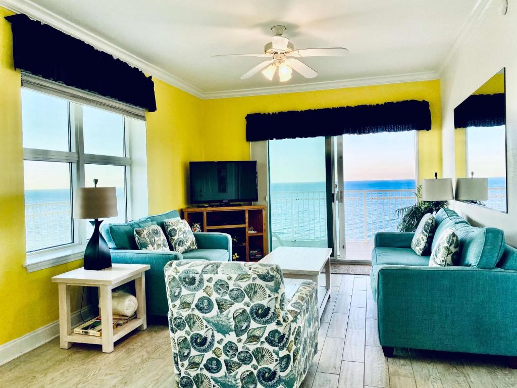 格尔夫海岸Crystal Shores 1301 by ALBVR - Beautiful Beachfront Corner Condo with Gorgeous Views!的客厅配有2张蓝色沙发和1台电视