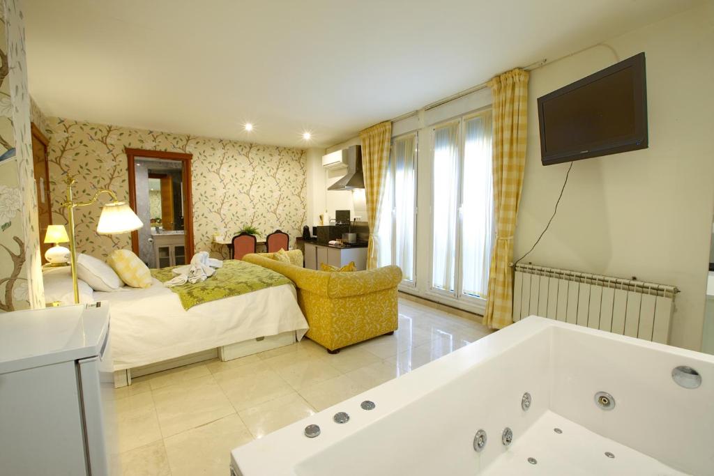 昆卡Apartamentos Chvictoria的一间带床和浴缸的客厅