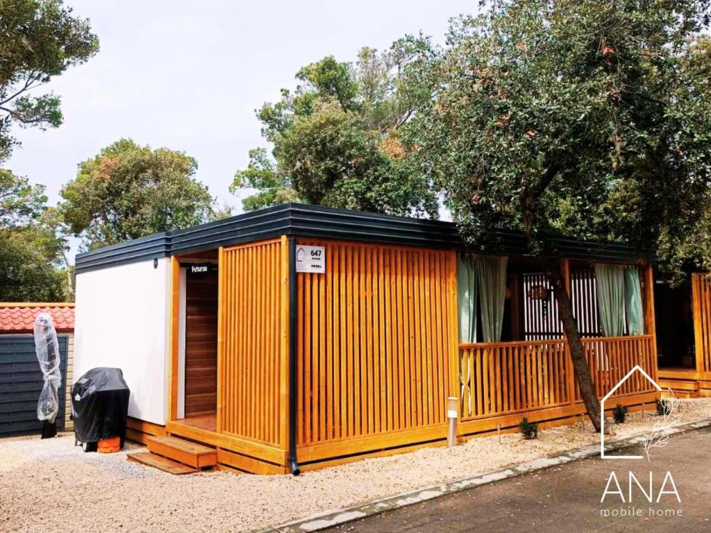 比奥格勒·纳·莫鲁Ana Mobile Home - Kamp Soline - Biograd na Moru的橙色和白色的带栅栏的棚子