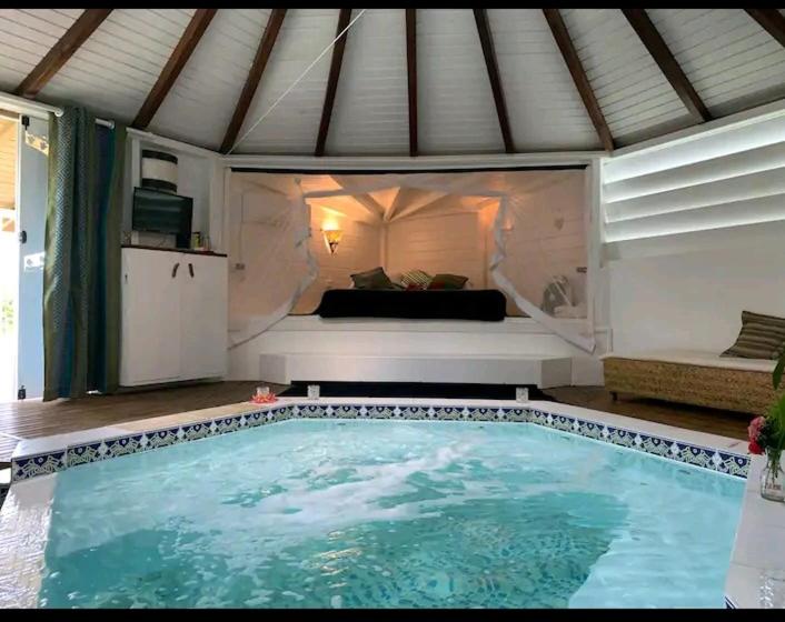 莱斯巴斯Le grand palm gîte tobago的一个带床的房间的大型游泳池