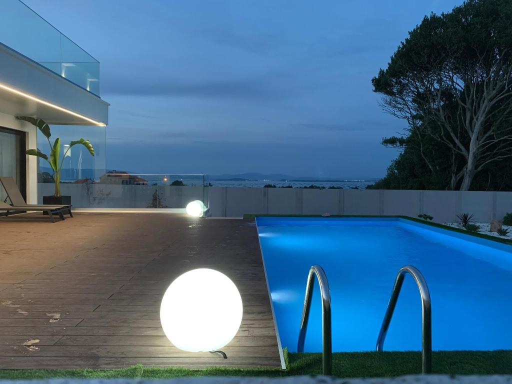 格罗韦Casa Leiras的一座房子旁带灯光的游泳池