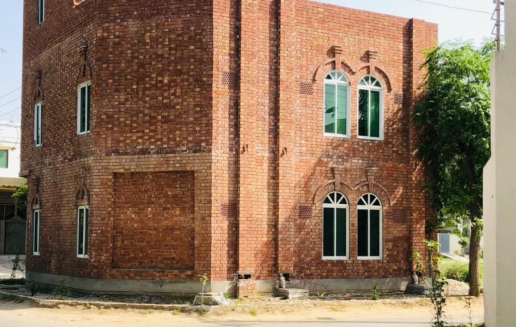 拉合尔Hosteller - Hostel & Hotel Johar Town Lahore的一面有窗户的红砖建筑