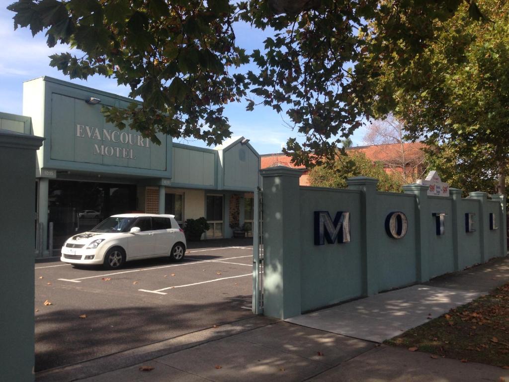 墨尔本Evancourt Motel Malvern East的停在大楼旁边的停车场的白色汽车