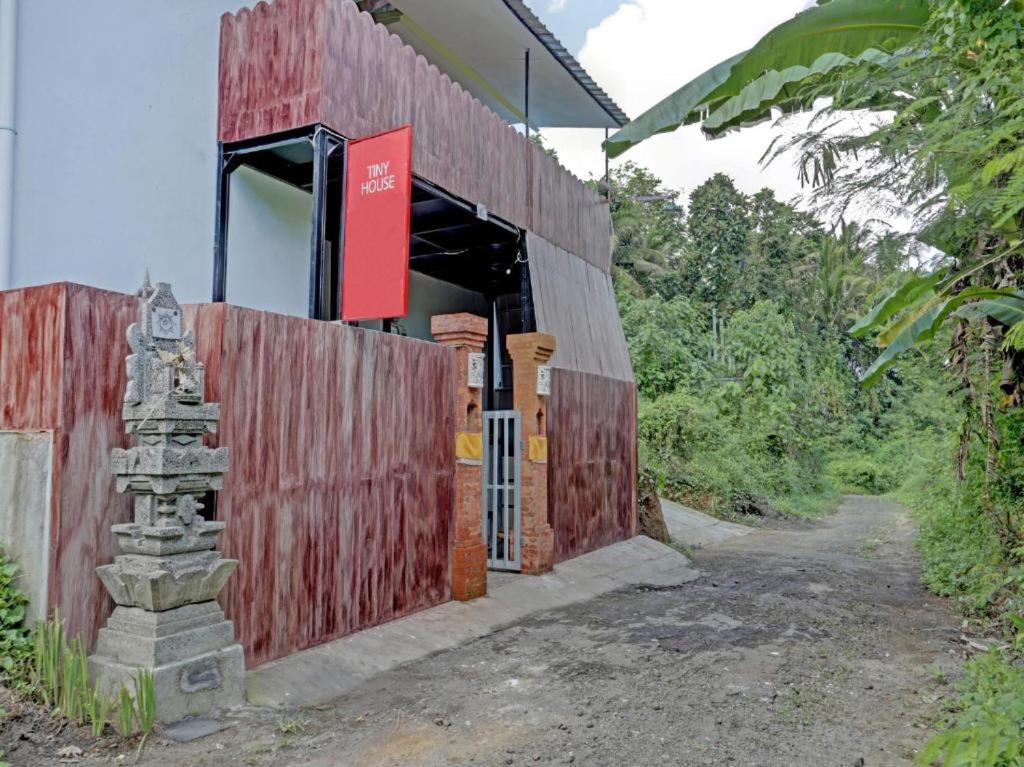 吉安雅Tiny House Gianyar的红色的木结构建筑,上面有红色的标志