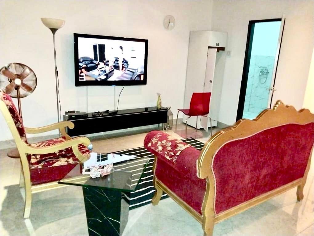 LaminYazmin’s studio apartments的客厅配有2把椅子和平面电视