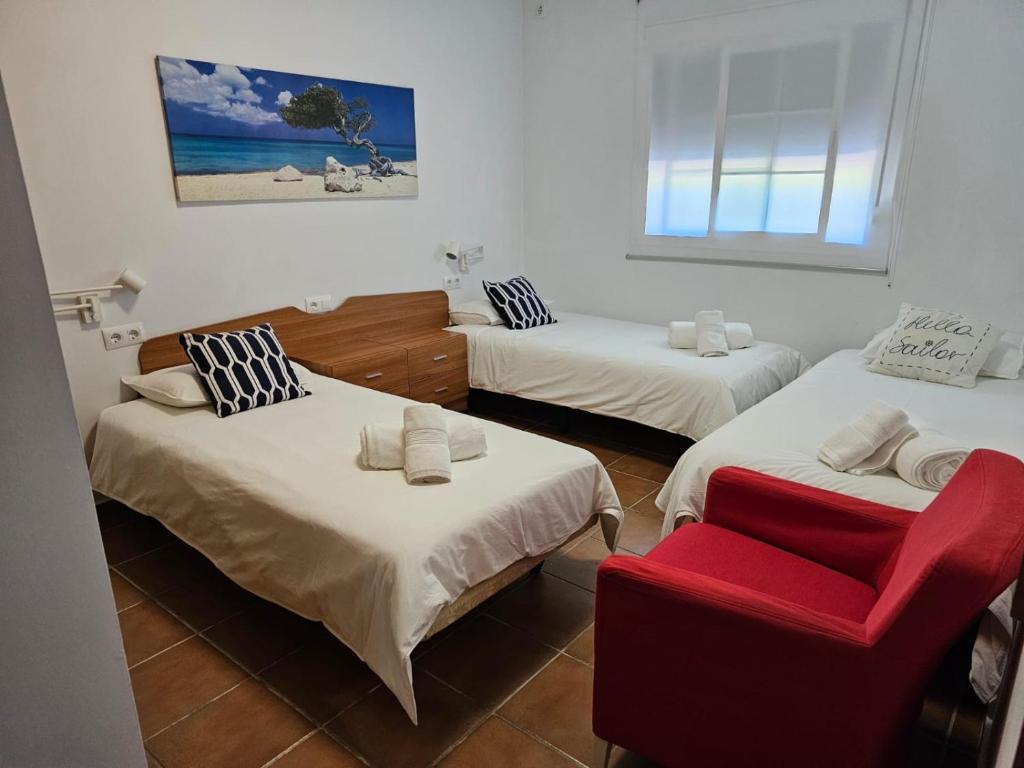 加的斯Villa Torrealta, 4000 m2, estancia mínima en verano 7 días de sábado a sábado的带三张床和红色椅子的房间