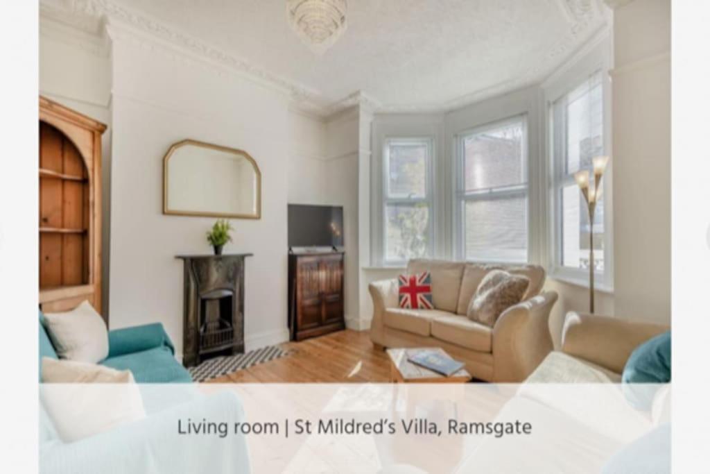 拉姆斯盖特St Mildreds Villa, Ramsgate Royal Harbour, Kent的带沙发和壁炉的客厅