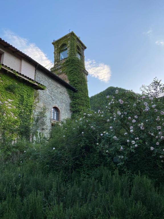 马尔扎博托基耶萨伊格那诺 1778酒店的一座常春藤覆盖的建筑,山上有塔