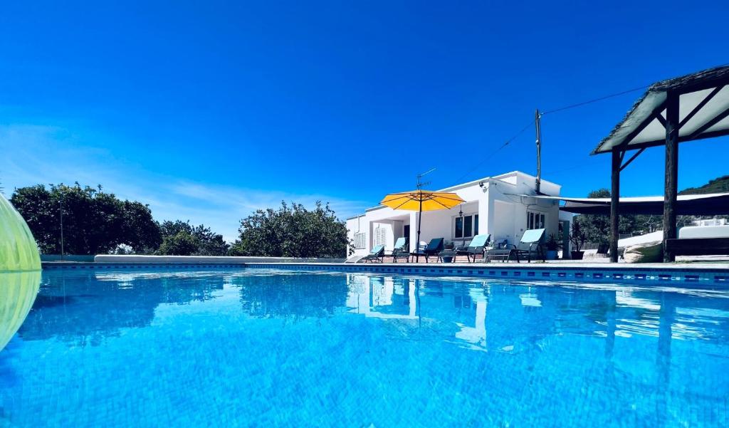 伊维萨镇THE LOVELY VILLA IBIZA的白色房子前的大型游泳池