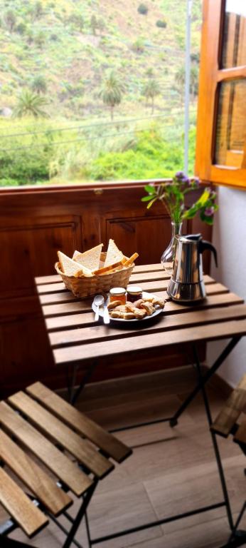 埃尔米瓜Casa Rural Antigua Escuela II的窗口上带一盘食物的桌子