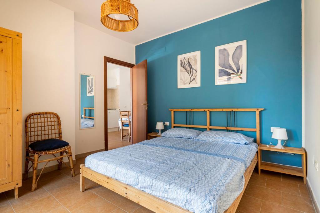 伯吉维奇Casa Vacanze Albarìa的蓝色卧室,配有床和椅子