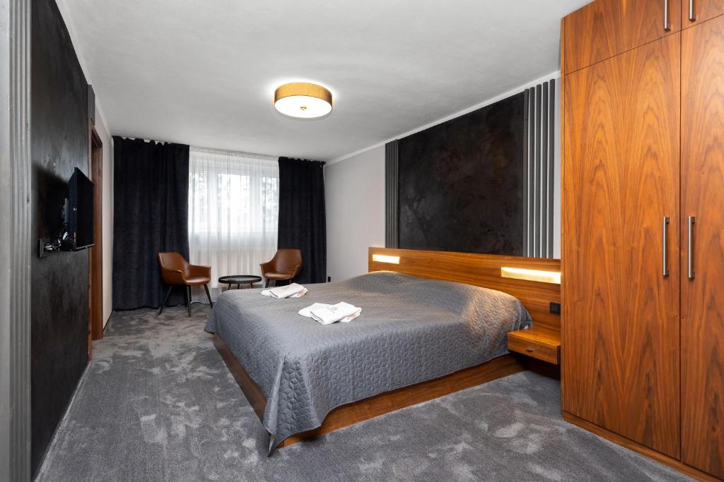 帕尔杜比采GARDEN Restaurant & Pension的酒店客房带一张床、一张桌子和椅子