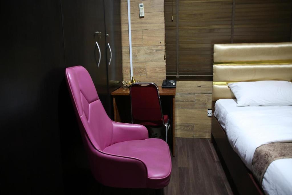 拉各斯HPLagos BT的酒店客房配有粉红色的椅子和书桌