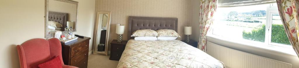 托玛斯镇Viewmount的卧室配有带枕头的床铺和窗户。