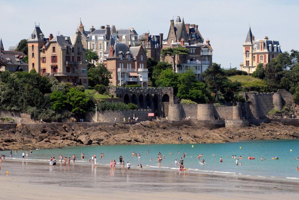 迪纳尔Proche St-Malo, plages, appart 50m2 avec jardin的一群人在海滩的水中