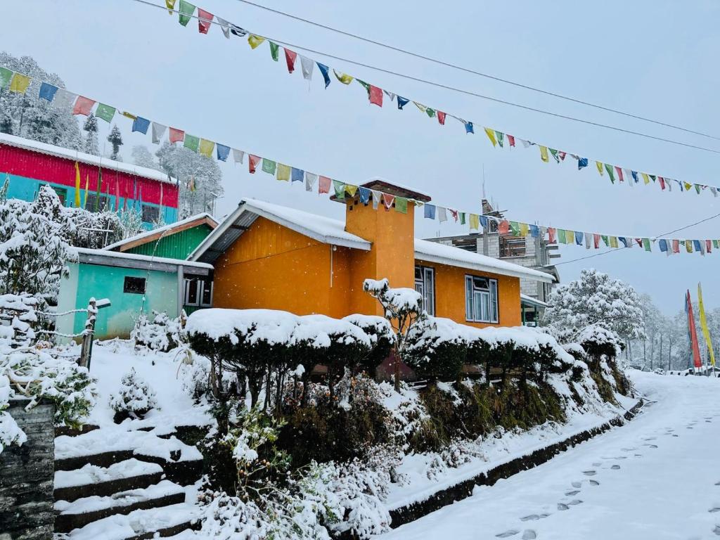 SombāriLali Gurash Homestay - Okhrey的一座建筑物前的雪覆盖的房子