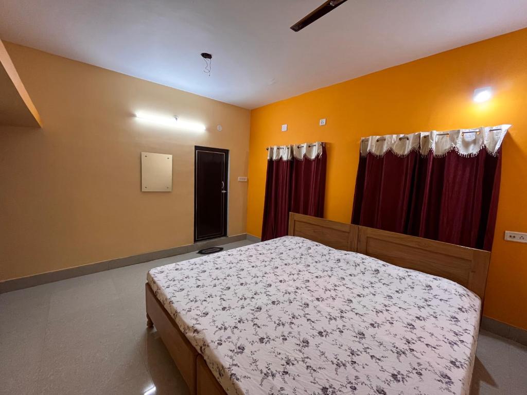 普里Shradharam Lodge的一间卧室配有床和红色窗帘