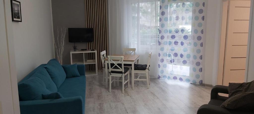 波别罗沃Apartament 4YOU的客厅配有蓝色的沙发和桌子