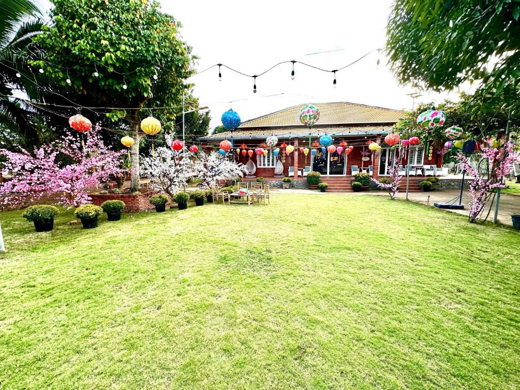 Ðồng SàiFamily Garden House at Tri An Lake, Đồng Nai的一个带有气球和鲜花的房子的院子
