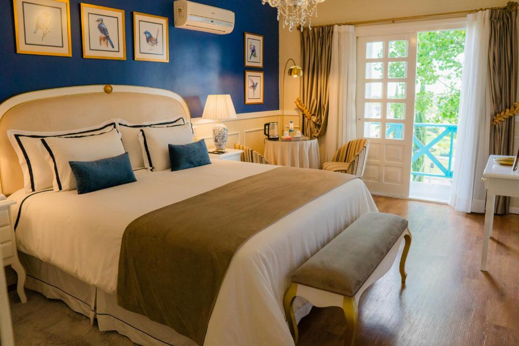 新彼得罗波利斯普萨达达内维酒店的一间卧室配有一张带蓝色墙壁的大床