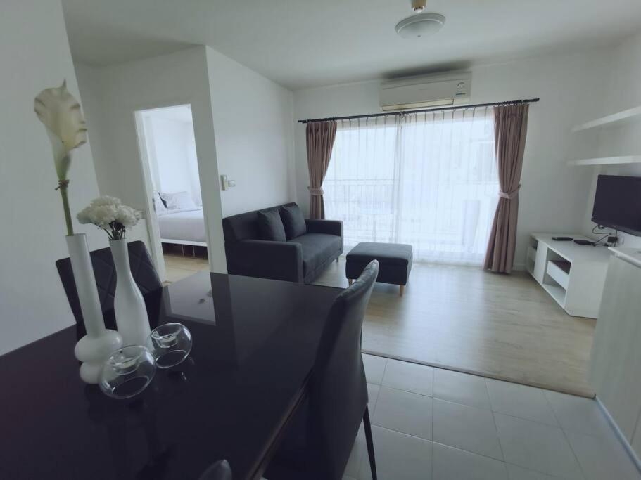 华欣Luxury 2 bedrooms condo in Kho Takiab的一间带餐桌的客厅和一间客厅。