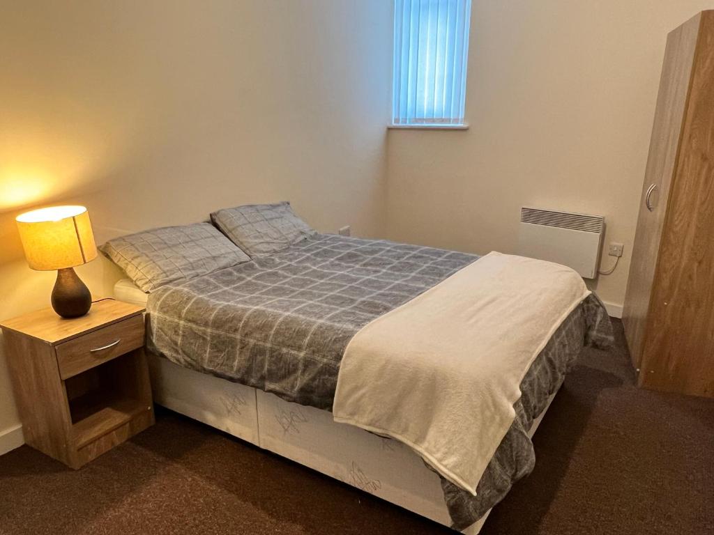 罗瑟勒姆Two Bed Town Apartment的一间卧室,配有一张床和床头灯