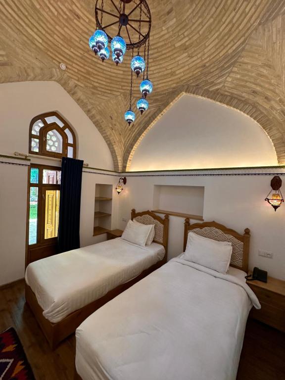 布哈拉Marhaba boutique Madrasah 15th-16th century的天花板客房内的两张床