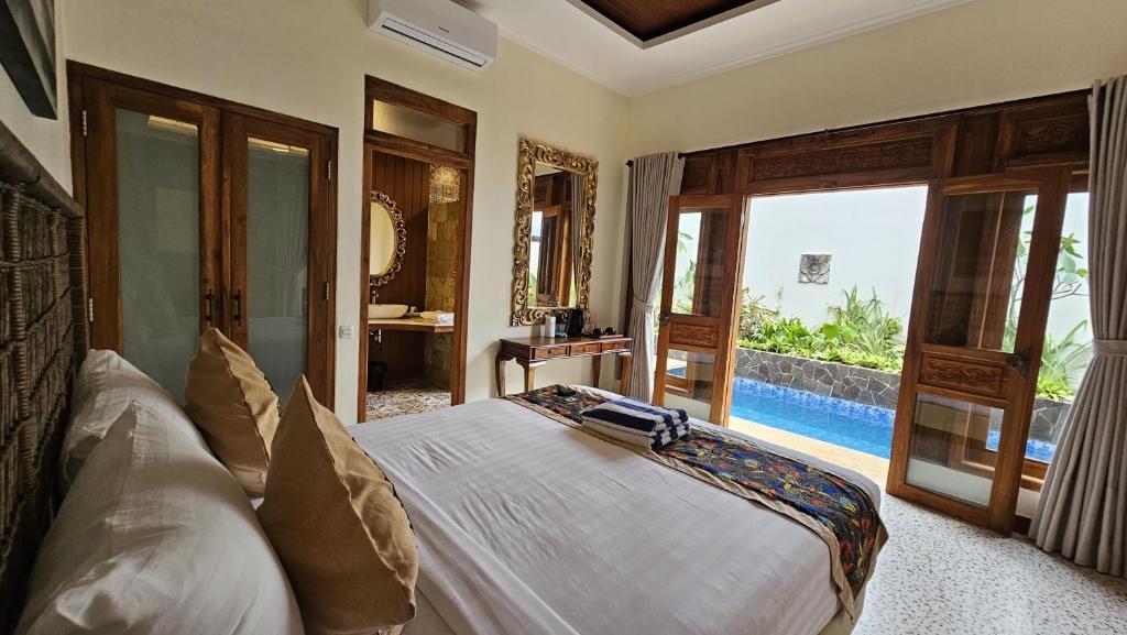 哲帕拉Jepara Garden Resort的一间卧室设有一张床,享有游泳池的景色