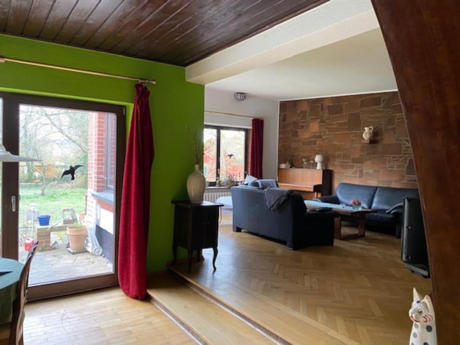 施特拉尔松德geräumiges 120m² Haus mit Garten + Stellplatz的客厅设有绿色的墙壁和蓝色的沙发