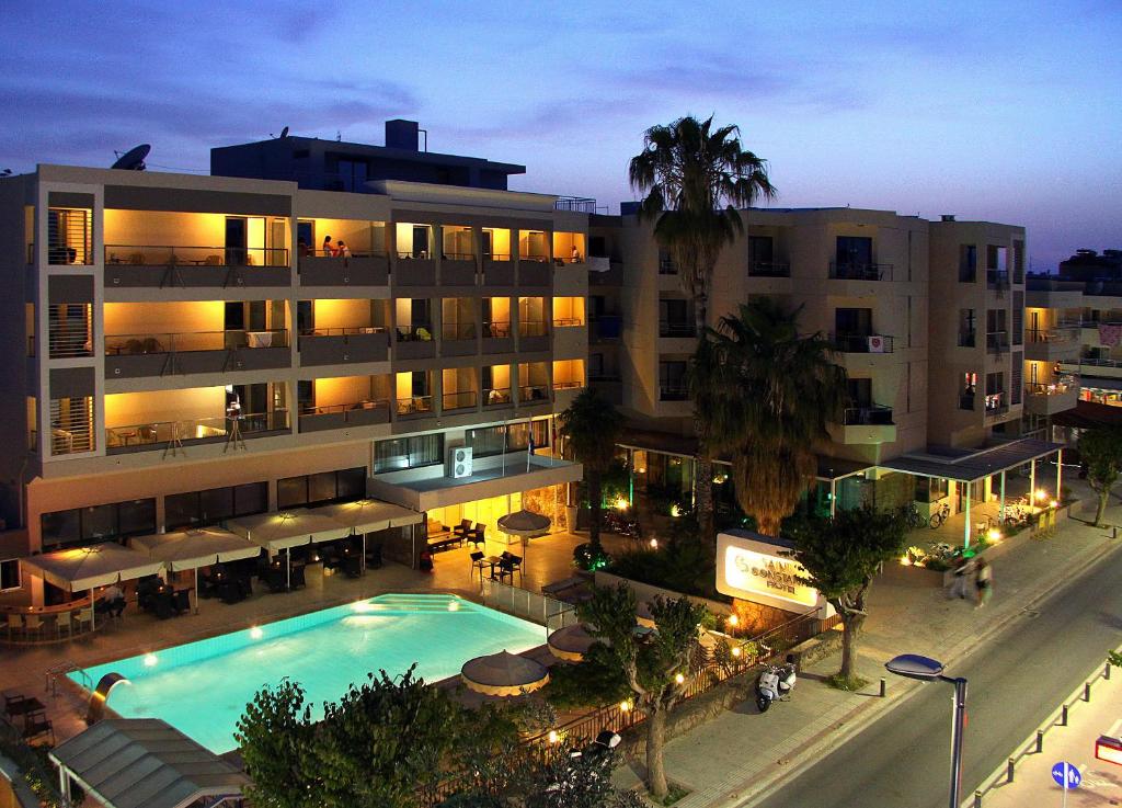 科斯镇圣君士坦丁公寓式酒店的一座大型建筑,前面设有一个游泳池