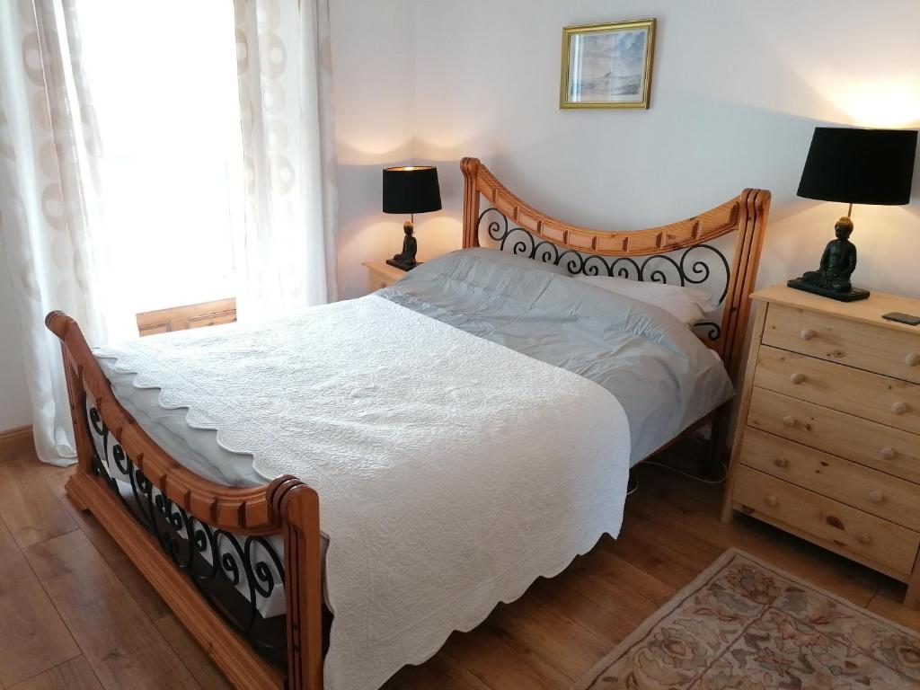 DunkineelyFerguson's Traditional Townhouse的一间卧室配有一张床和一个带两盏灯的梳妆台。