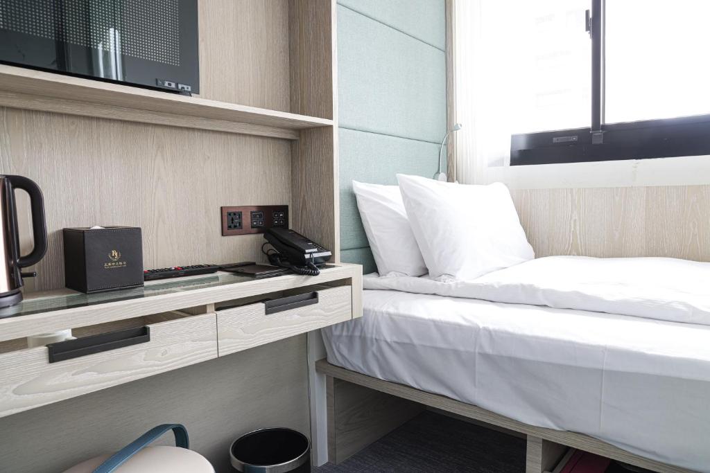 台北玉玺精品饭店的酒店客房,配有一张带电话的床