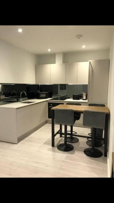坎伯利Central Camberley Apartment - Parking - Garden的厨房配有白色橱柜和桌子