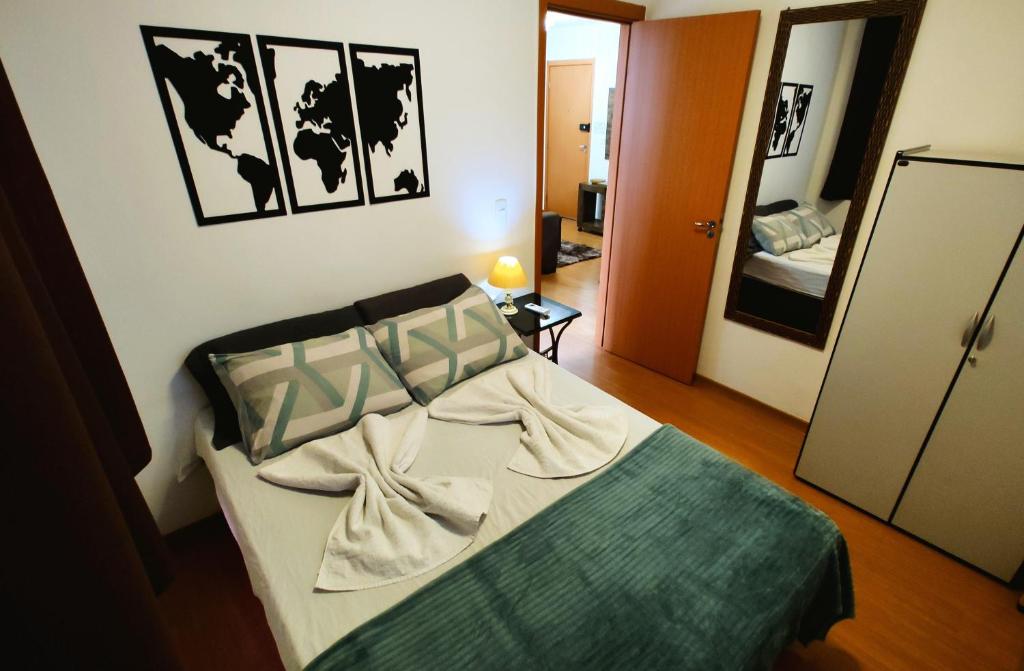 大坎普Apto Executivo Ravena的一间设有一张床铺的卧室,位于一个带镜子的房间