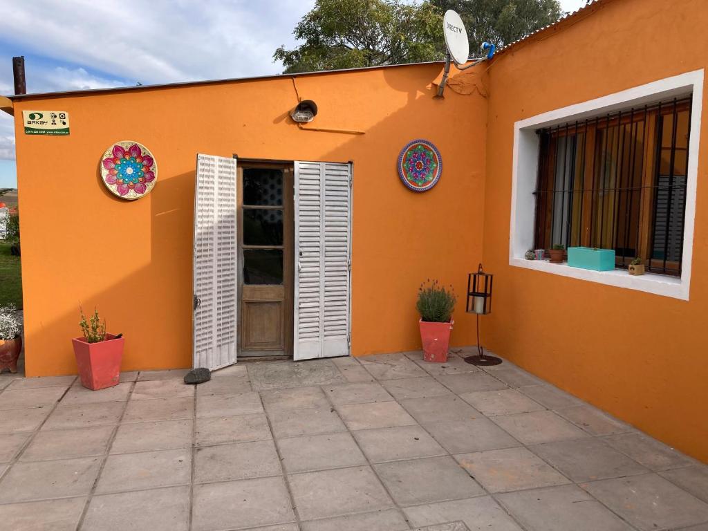 坦迪尔Casa de campo rústica的橙色的房子,设有门和庭院